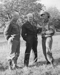 Ernie Pyle converses standing with two officers.