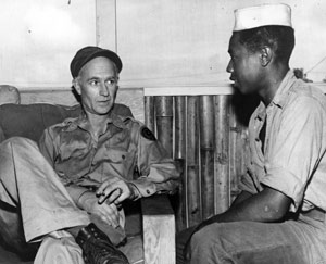 Ernie Pyle sits with a soldier.